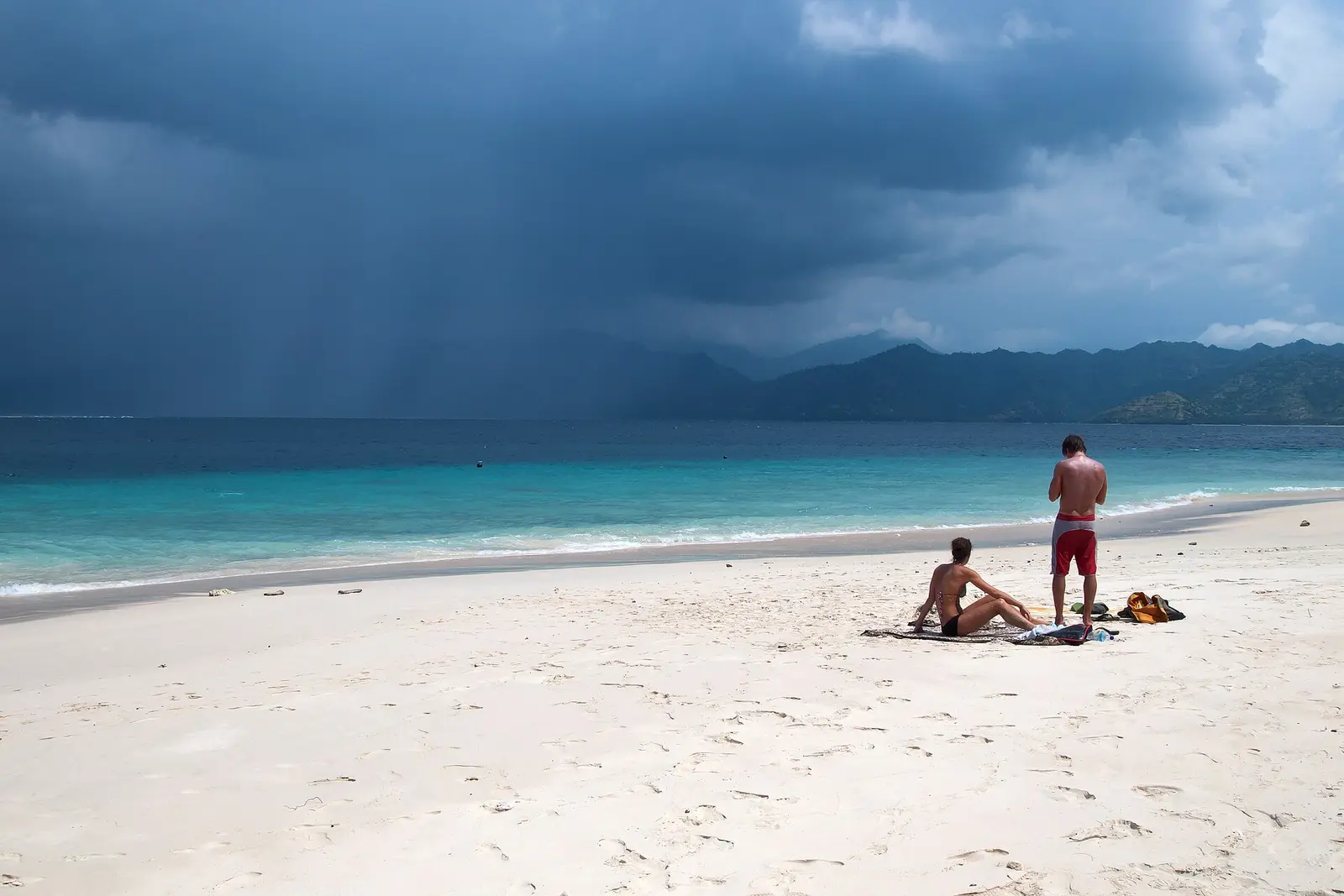 Beach on the island. Equatorial tropical thunderstorm clouds over the Lombok Strait, Gili Meno Island,…