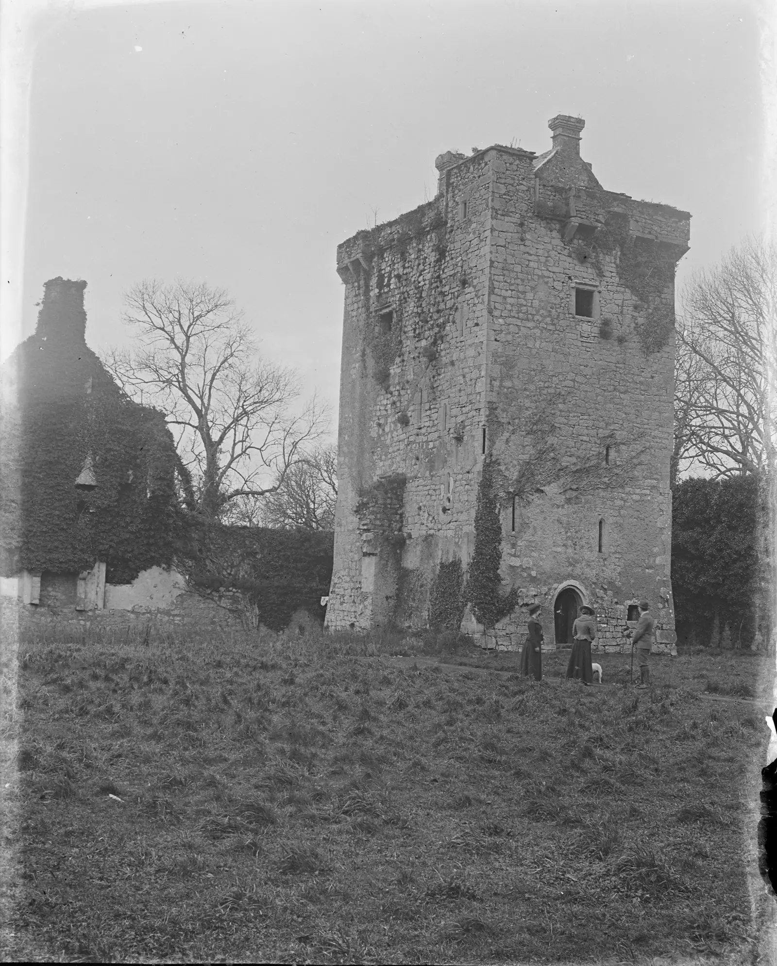[Shane's Castle, 1903] Two women, a man and a dog standing in front of the ruins of Shane's Castle Randals…